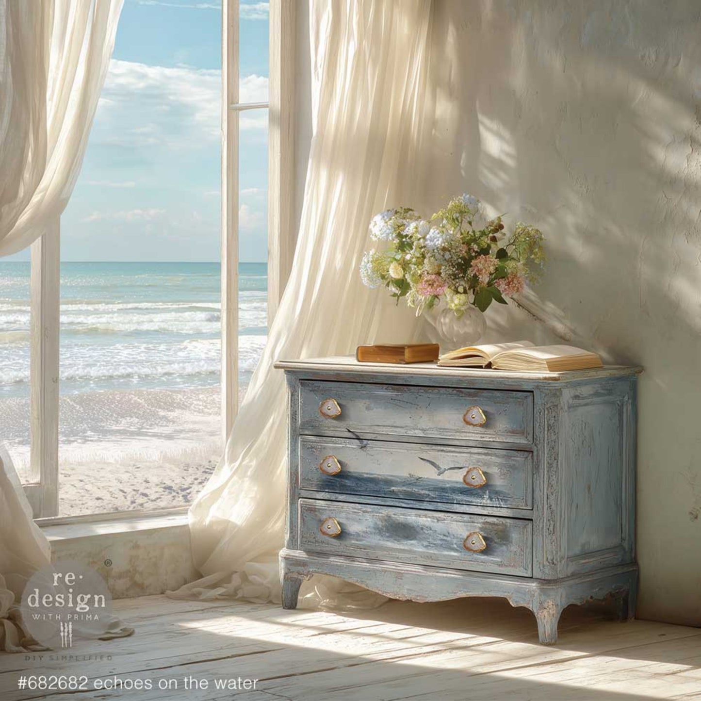 Coastal decoupage tissue paper design with soft blue water, white seafoam, and neutral beach colors on a blue dresser