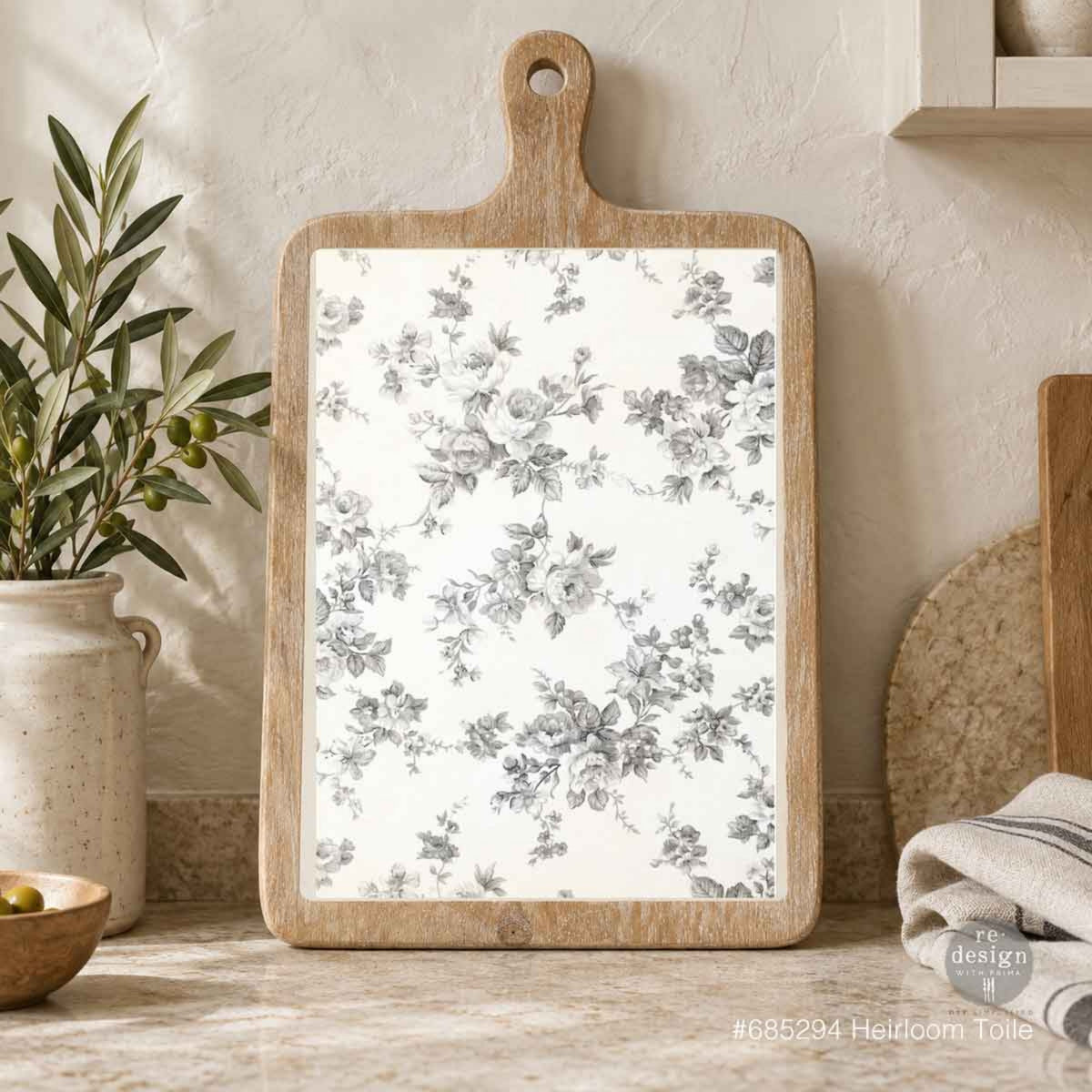 Heirloom Toile decoupage fiber paper displayed on a rustic wooden cutting board, featuring vintage gray roses and delicate floral sprigs on an ivory background.