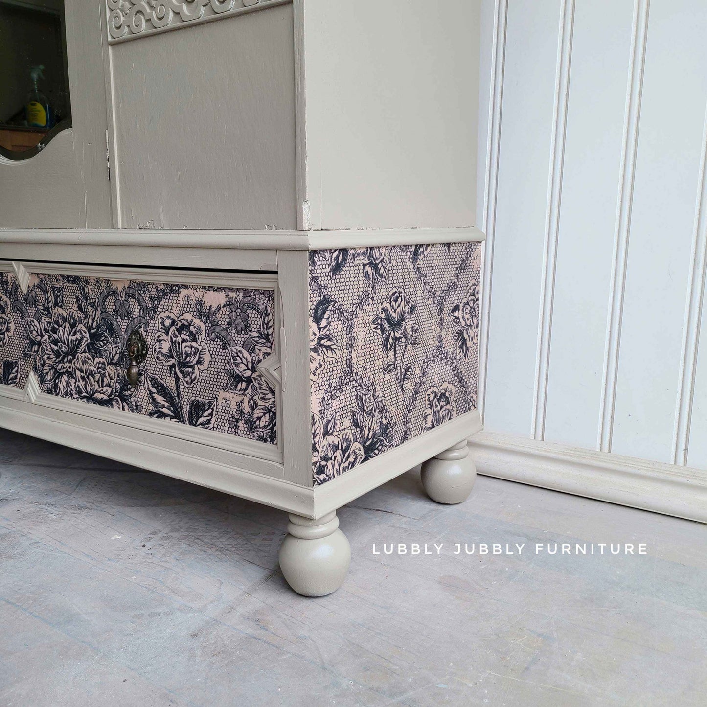 Antique Laces decoupage fiber paper used on the lower drawer and side panel of a soft neutral painted cabinet with vintage detailing.