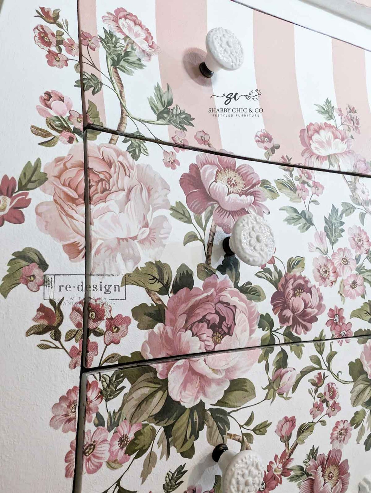 Close-up of Blushing Blooms Symphony floral transfer on dresser drawers with blush pink stripes, white knobs, and soft cottage-style flowers.