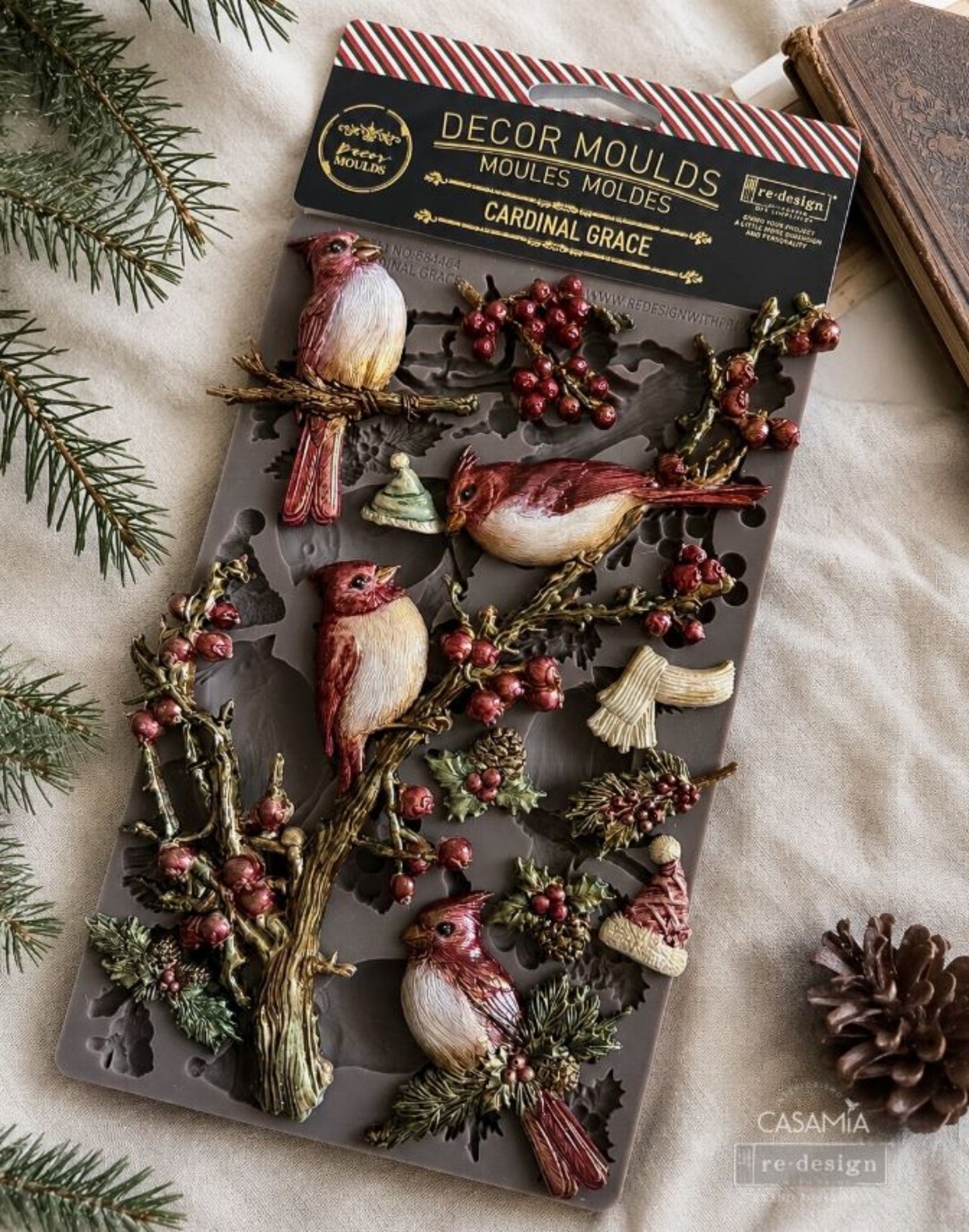 Cardinal Grace Décor Mould shown with painted cardinal birds, berry branches, pine sprigs, hats, and winter accents.
