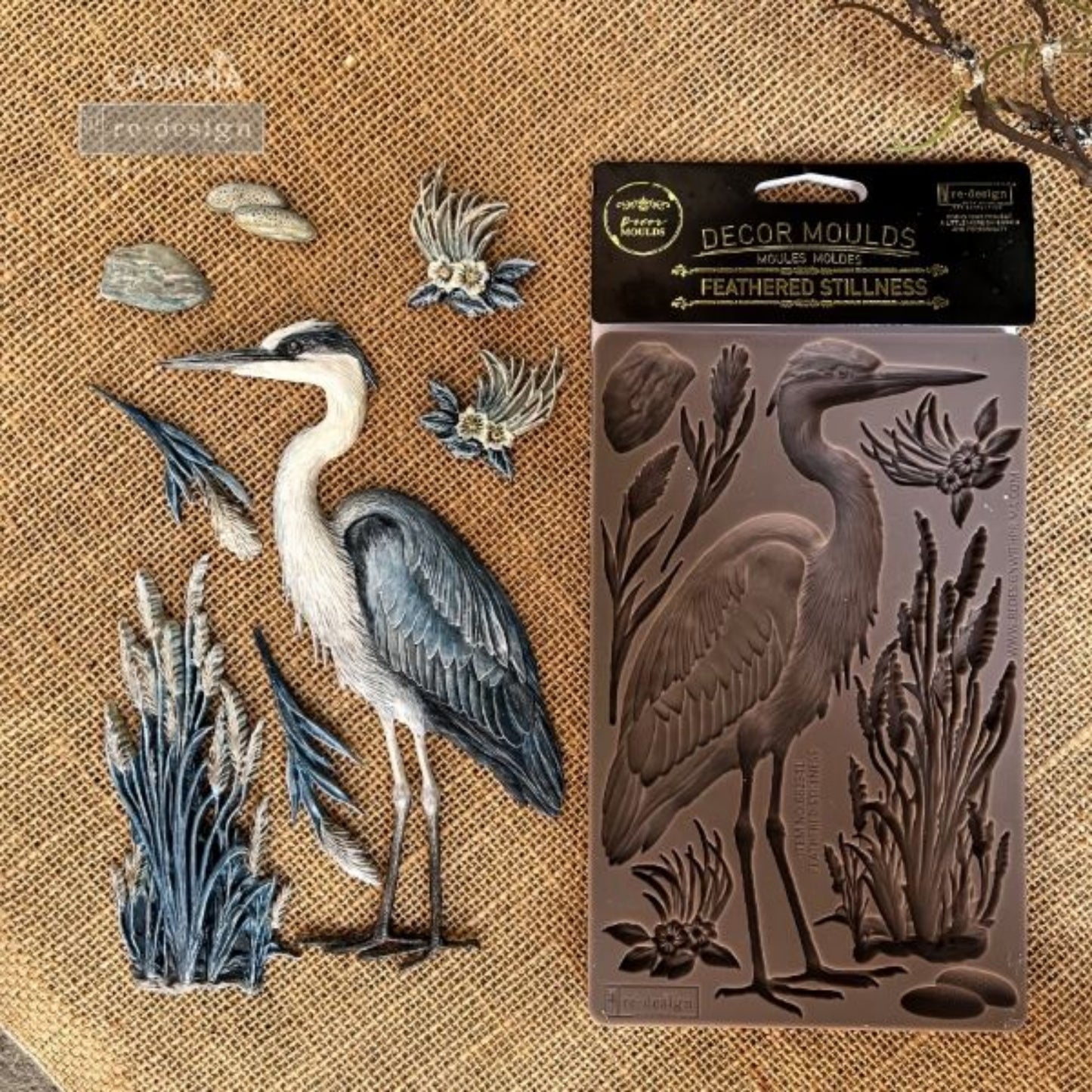 Feathered Stillness Decor Mould showing a graceful heron-style bird with cattails, reeds, flowers, leaves, and stones for nature-inspired projects.