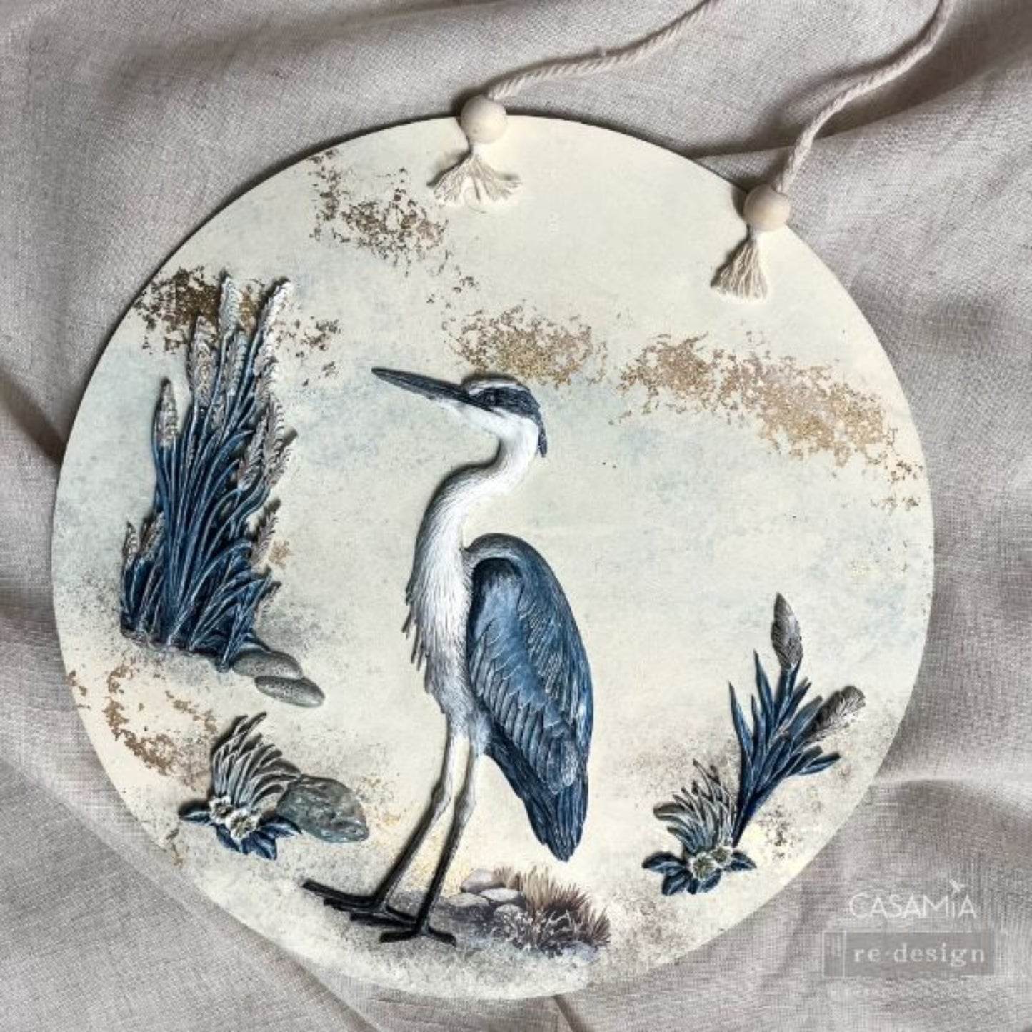 Close-up of Redesign with Prima Feathered Stillness mould with detailed bird feathers, cattails, reeds, flowers, and organic textures on a round decor hanging picture