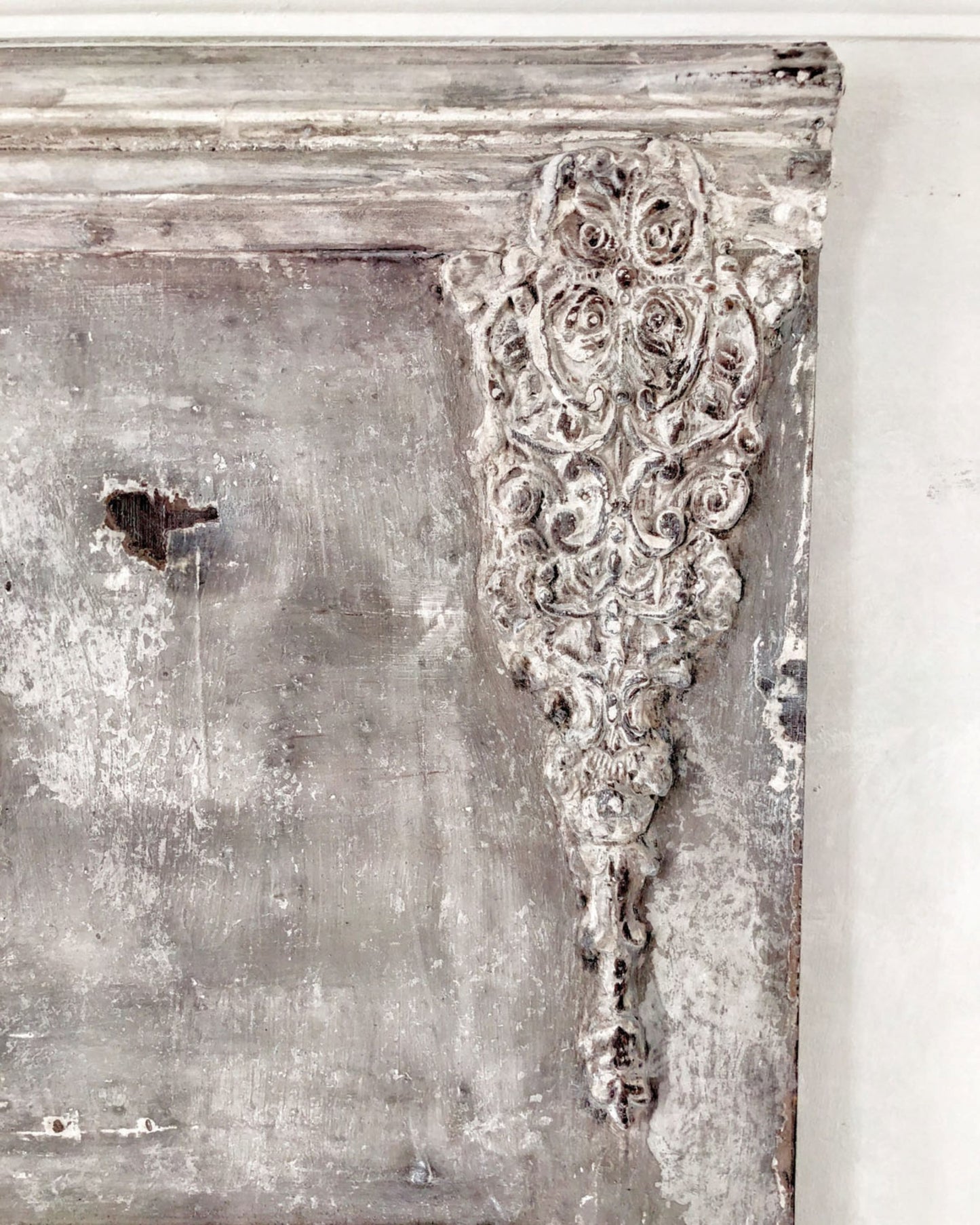 Golden Emblem Decor Mould casting applied to a distressed French country furniture piece, adding raised ornate detail with a weathered whitewashed finish.
