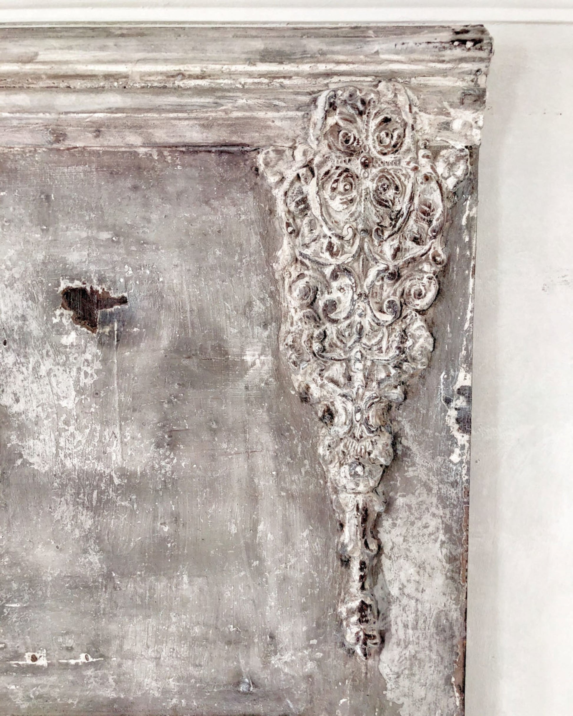 Golden Emblem Decor Mould casting applied to a distressed French country furniture piece, adding raised ornate detail with a weathered whitewashed finish.