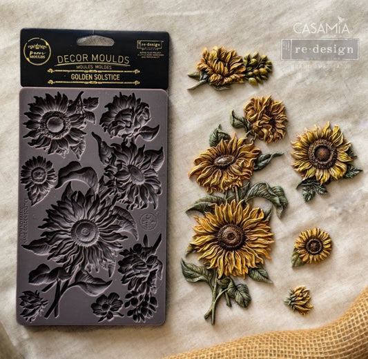 Golden Solstice Décor Mould displayed beside finished sunflower, bud, leaf, and stem castings.