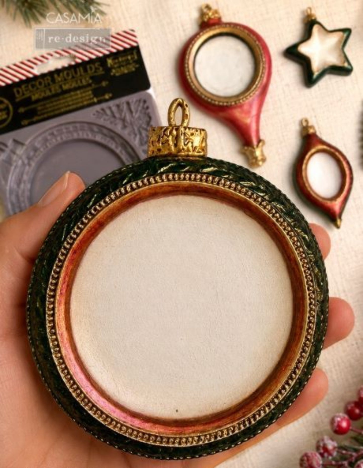 Noel Elegance Decor Mould packaging shown with a finished ornament sample in Christmas colors on a festive background.