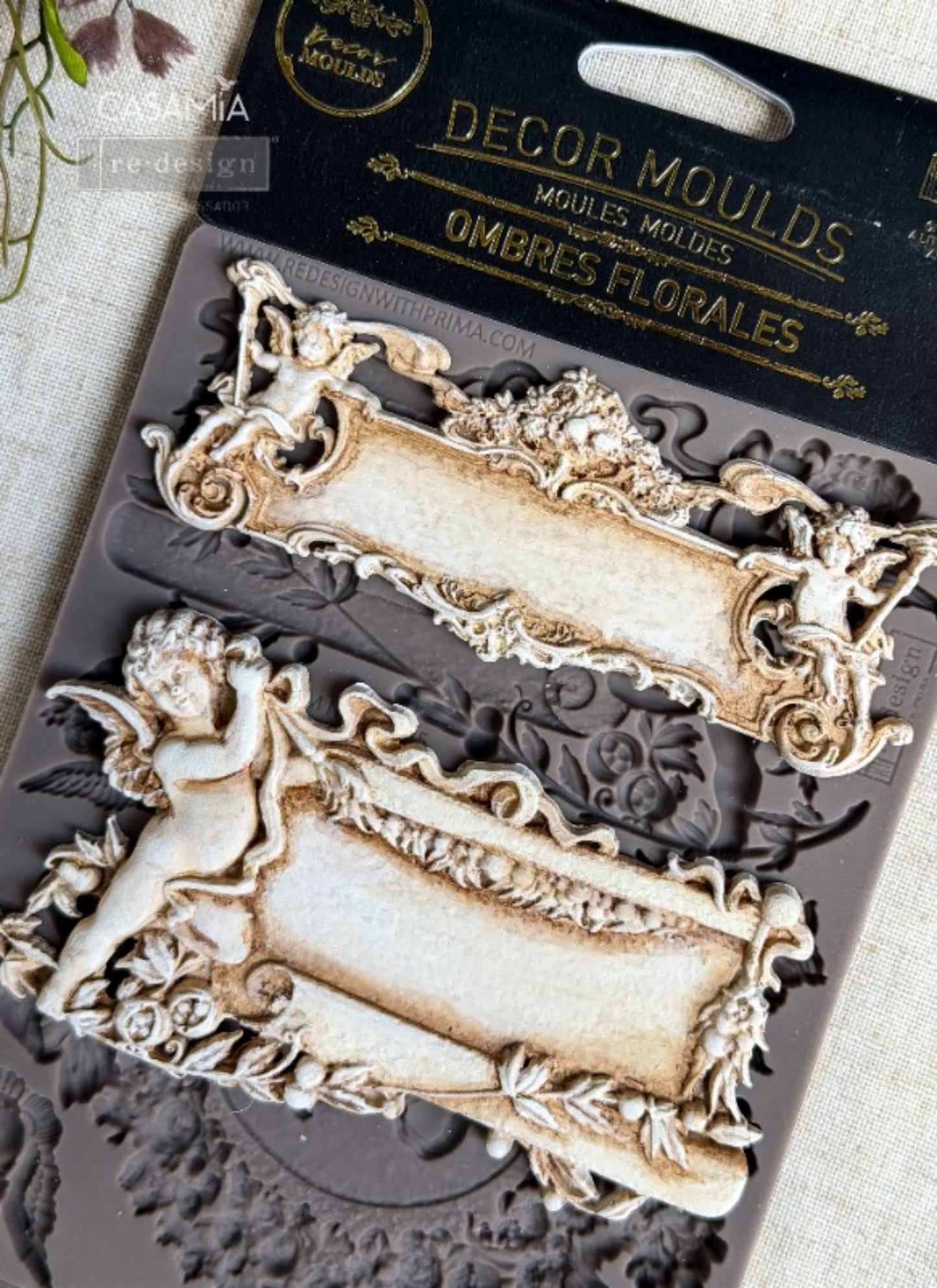 Redesign with Prima Ombres Florales silicone decor mould with cameo portrait, ornate frames, cherubs, bows, floral wreath, and scroll details.