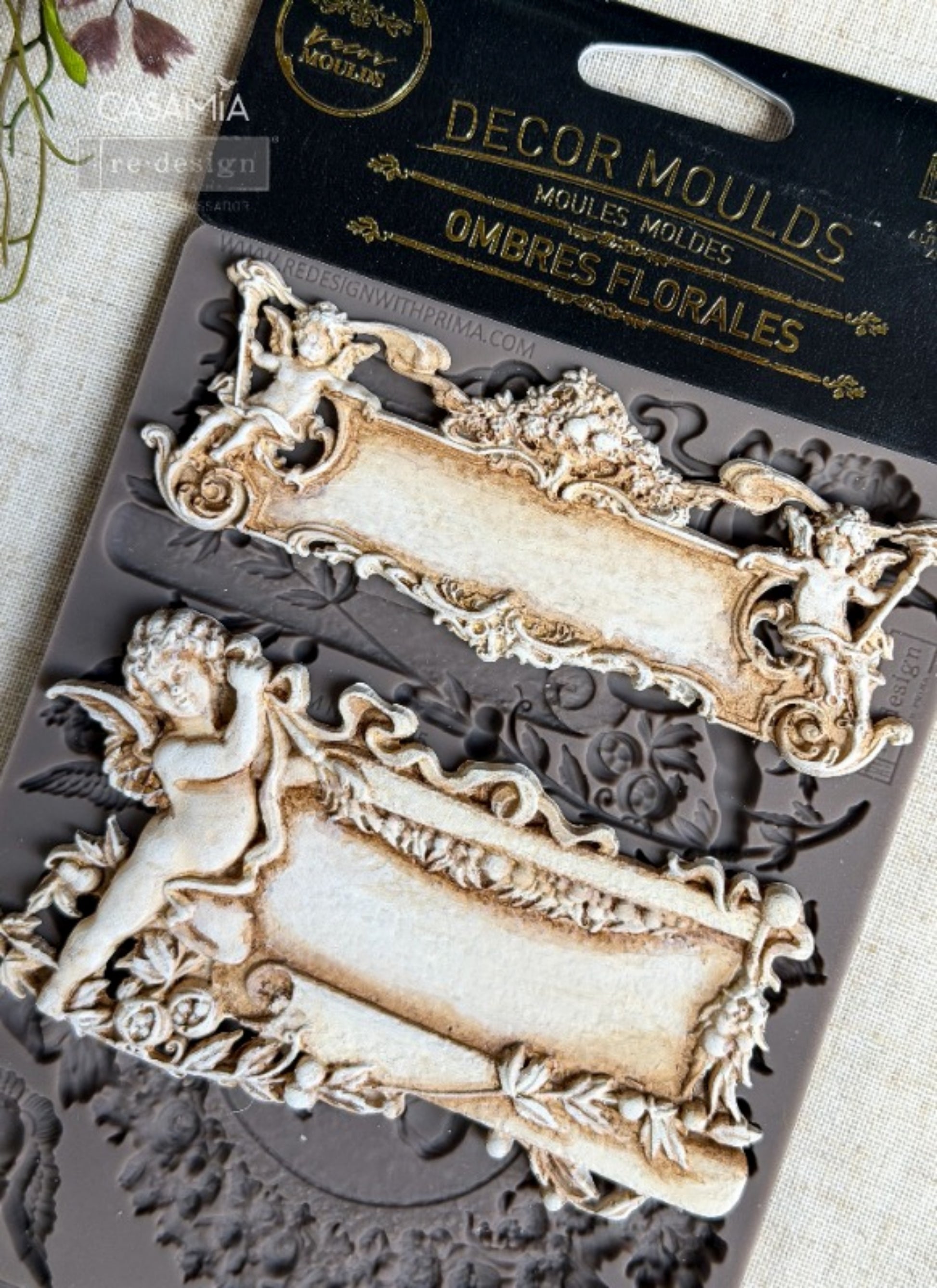 Redesign with Prima Ombres Florales silicone decor mould with cameo portrait, ornate frames, cherubs, bows, floral wreath, and scroll details.
