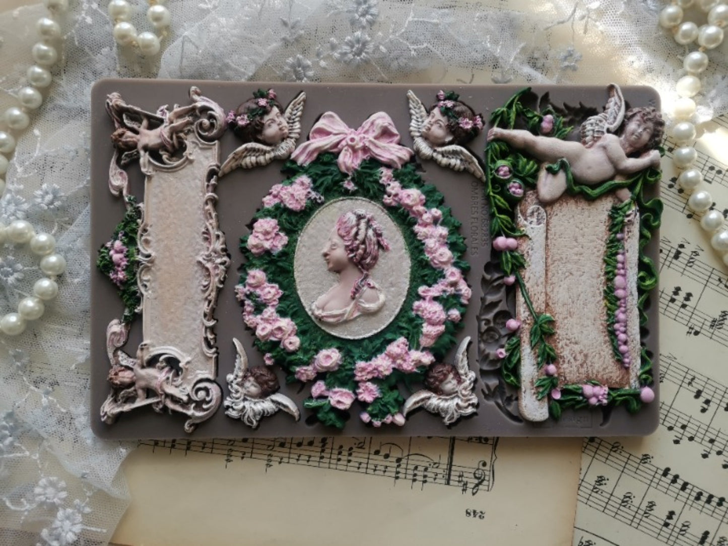 Redesign Decor Moulds Ombres Florales design featuring cherubs, bows, floral wreath, cameo portrait, and ornate European-inspired details.