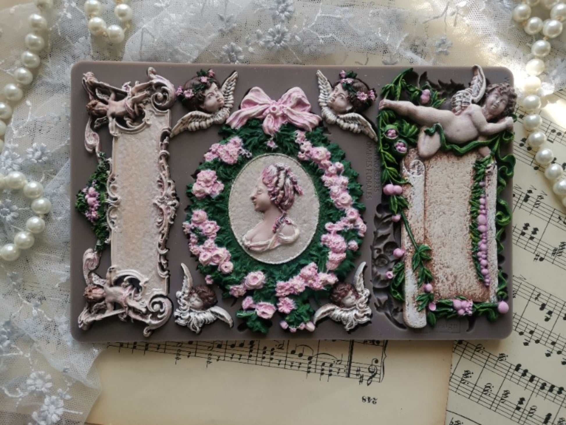 Redesign Decor Moulds Ombres Florales design featuring cherubs, bows, floral wreath, cameo portrait, and ornate European-inspired details.