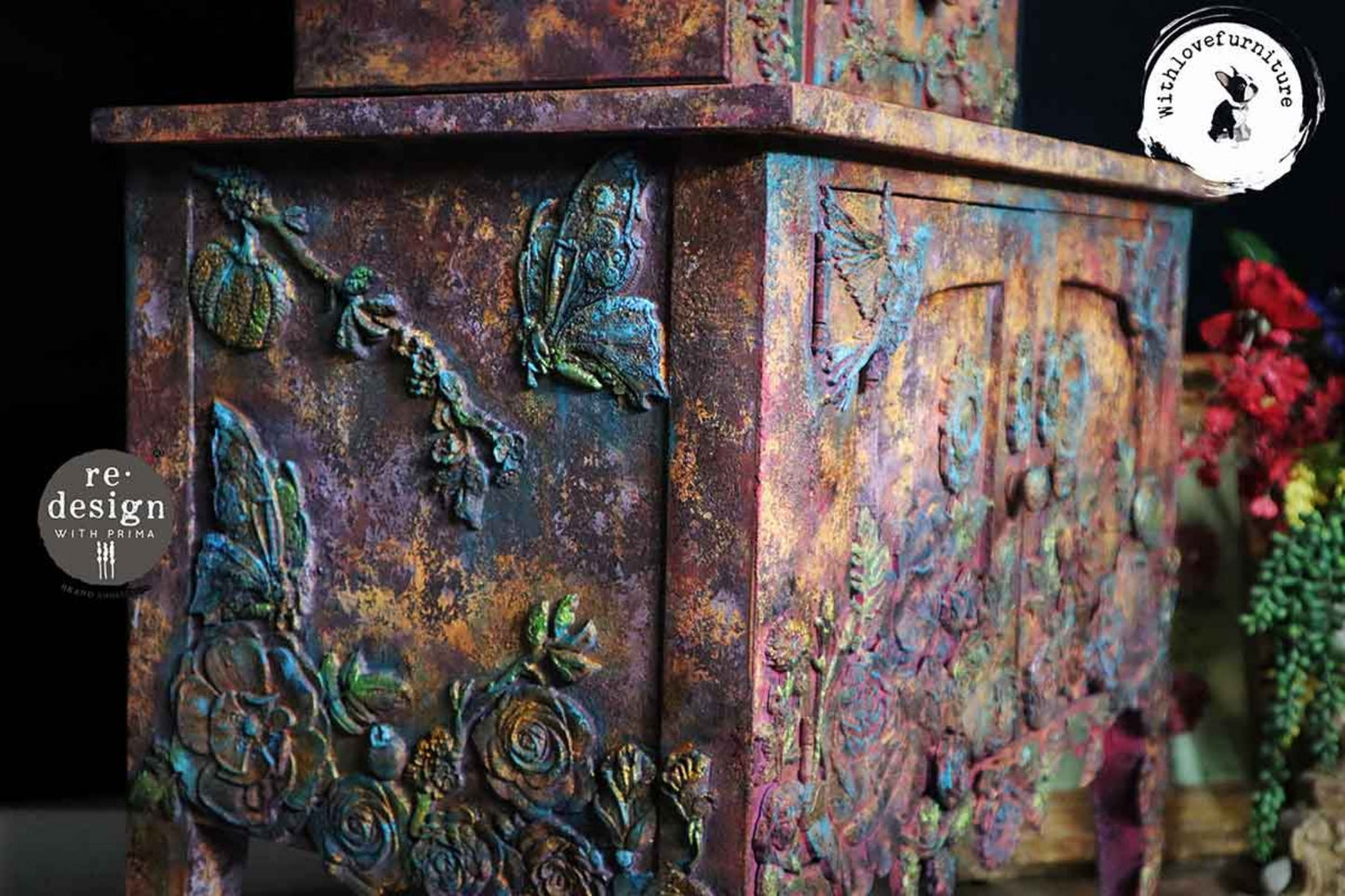 Close-up of a mixed media furniture project featuring Steamflight Symphony butterfly accents with layered bronze, teal, purple, and rust finishes.