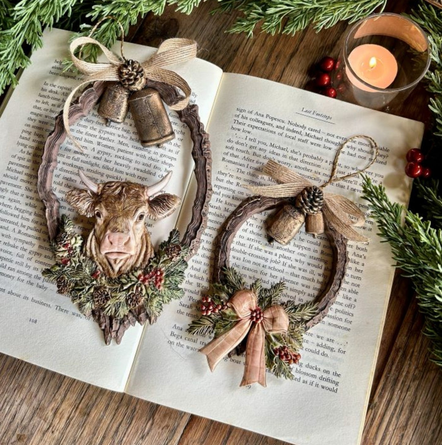 Two rustic Christmas wreath ornaments featuring a cow, bells, bows, pinecones, and winter greenery from the Winter Barnstead Décor Mould.