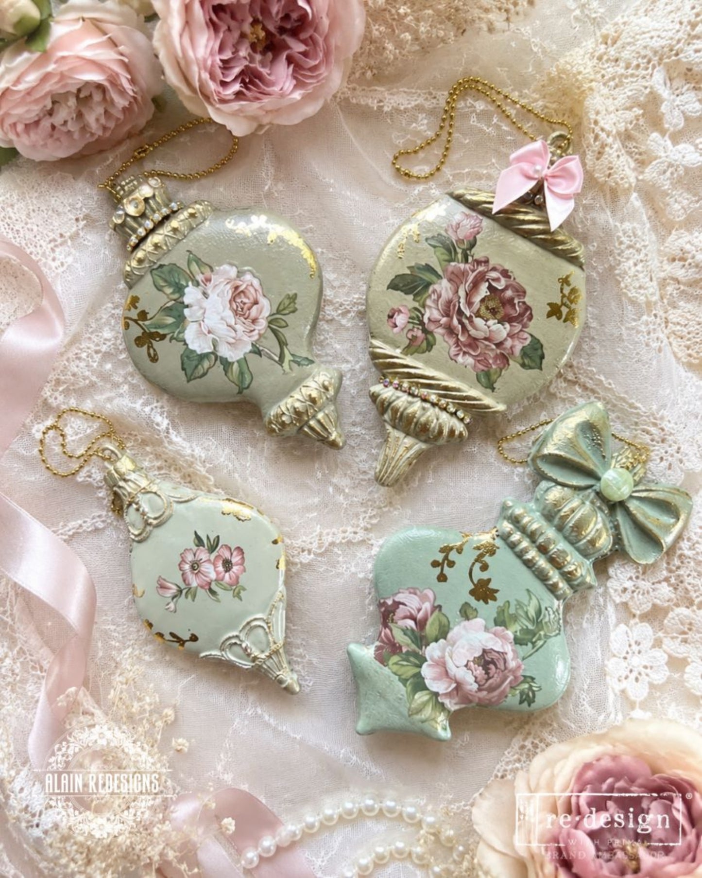 Winter Luxe Blanks ornaments decorated with soft pink floral designs, pale sage finishes, gold accents, bows, and hanging chains on vintage lace.