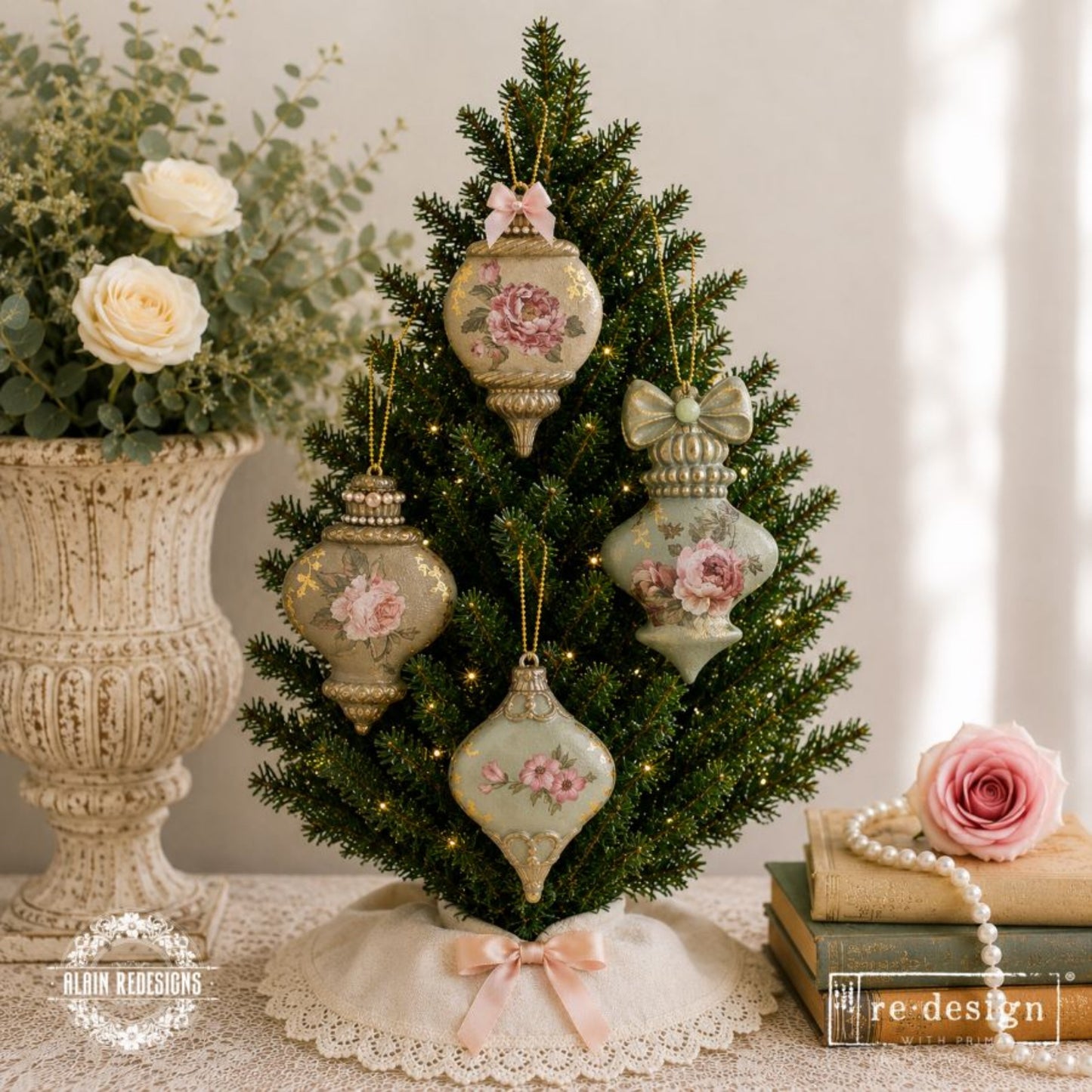 Three cast ornament blanks painted in warm burgundy, bronze, and antique gold finishes beside pinecones and winter berries.